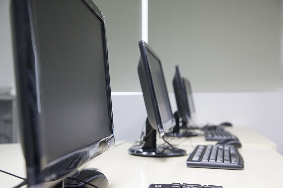 Computers in room representing the human farms that create fraudulent accounts