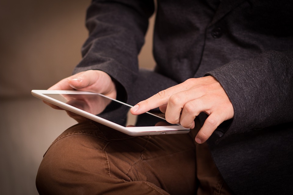 Man holding tablet swipes on screen